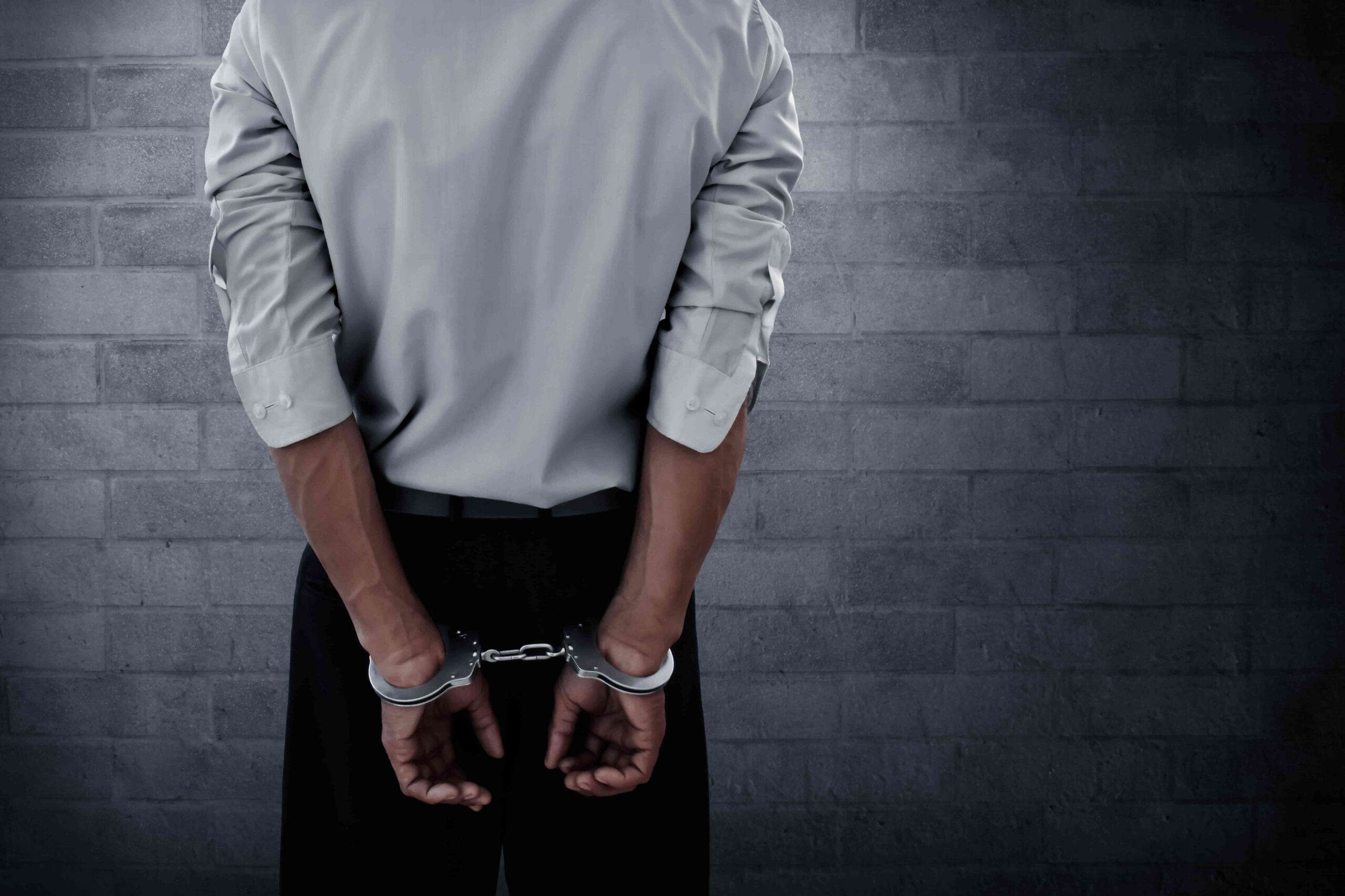 man in suit in handcuffs